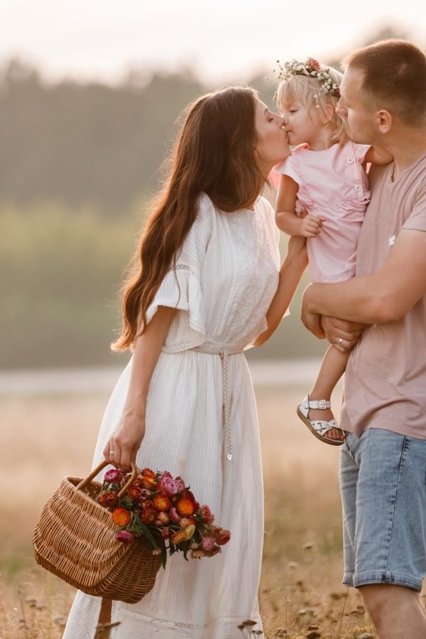 Portrait of happy family. Mom, dad and daughter walk in the field. Young family spending time